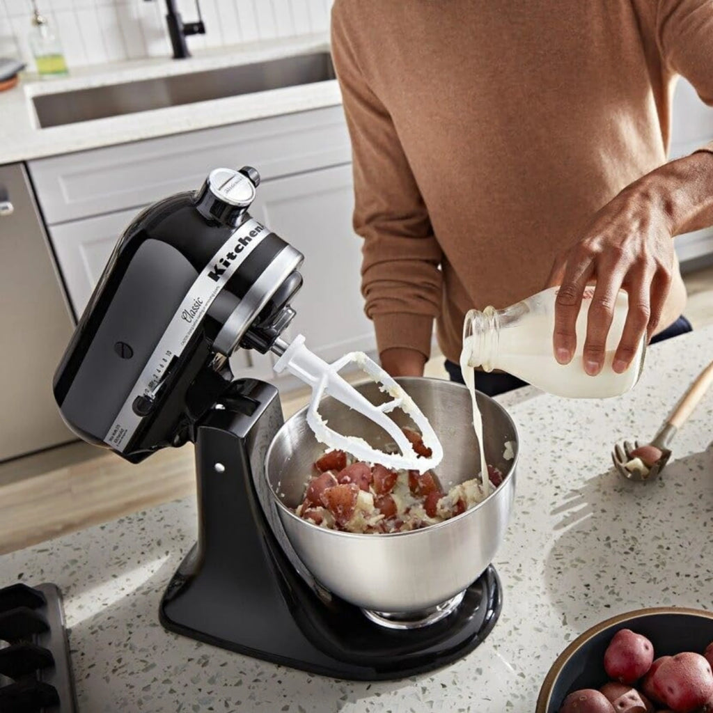 Batidora Planetaria Artisan KitchenAid negra con una persona usandola